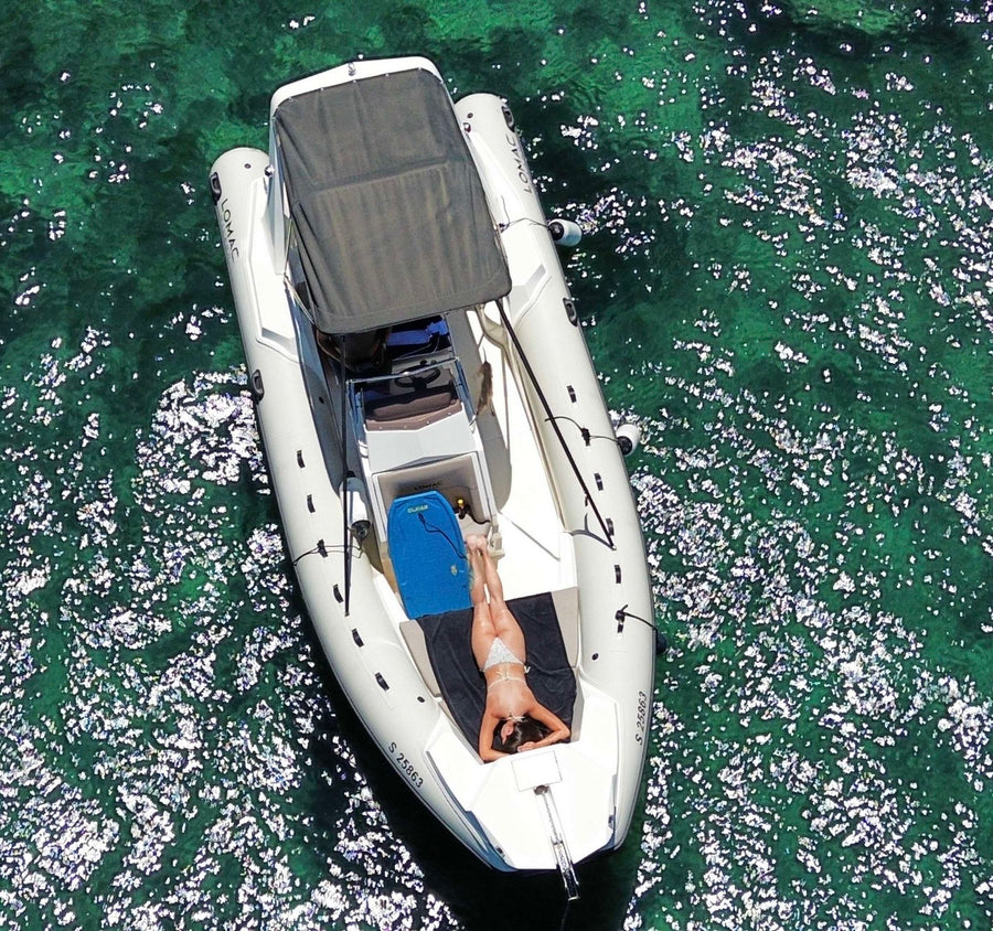 Aerial view of the RIB at anchor, with a passenger in the sun