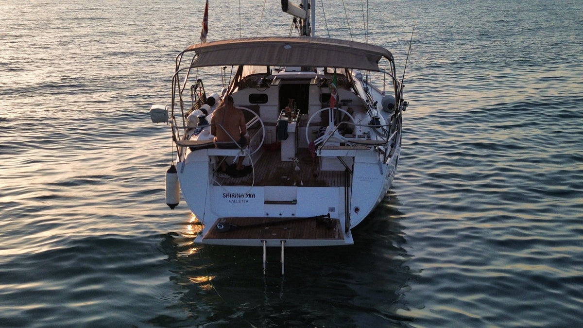 Back of the sailing yacht at anchor with guests on board