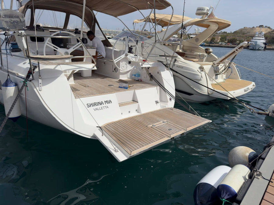Back of the sailing yacht moored at the marina, with the swim platform open
